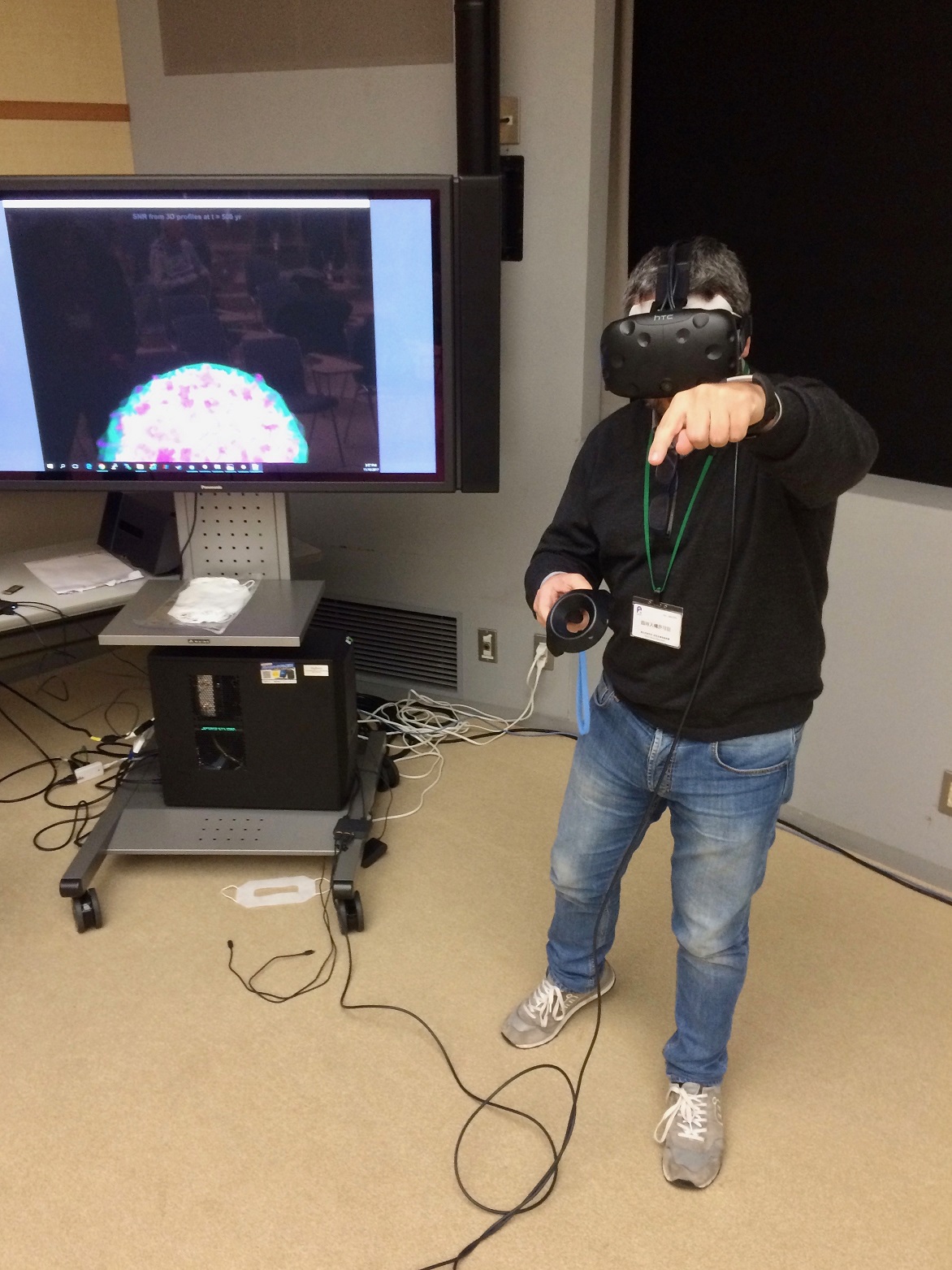 A researcher participating in the international workshop 'Theories of Astrophysical Big Bangs' interacting with a live 3D visualization of the latest supernova remnant simulations from G. F., after hearing the science talk about it.