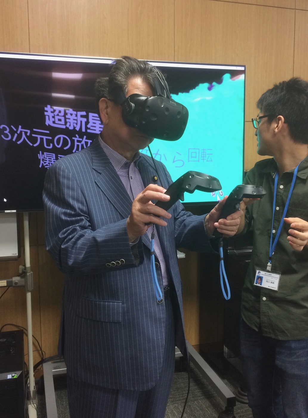 The State Minister of Education, Culture, Sports, Science and Technology is given a VR demonstration during his visit of RIKEN.