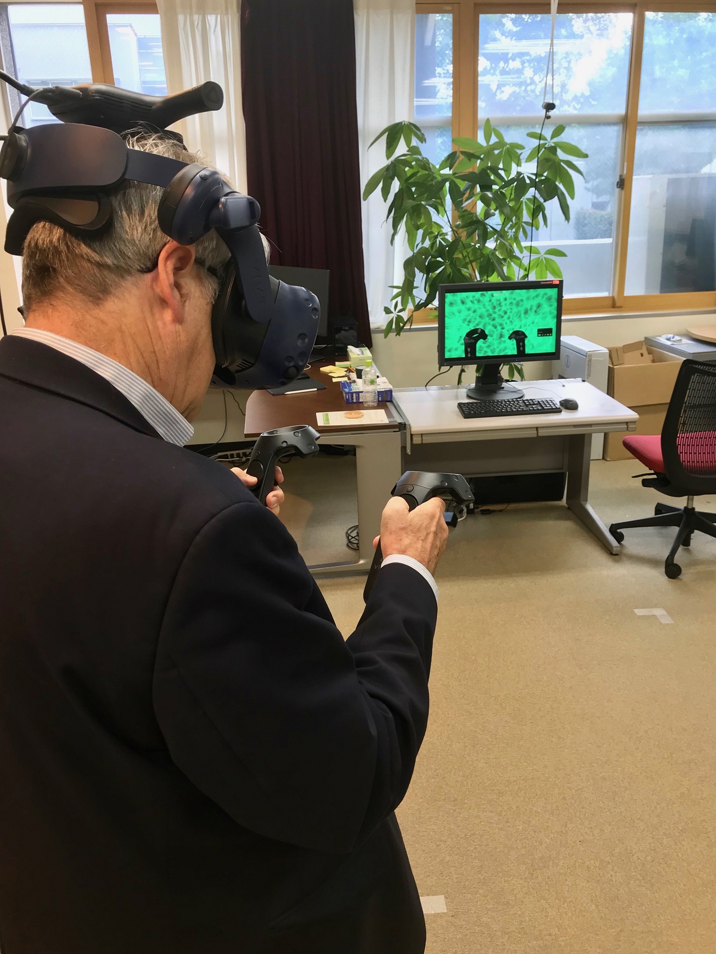 An external reviewer of the iTHEMS Advisory Council is checking out VR development work.